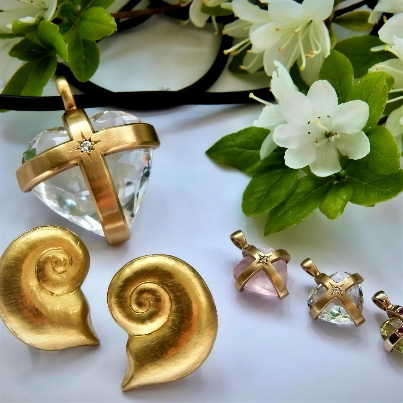 Herzanhänger aus Bergkristall mit Goldkreuz und Brillant, dazu Ohrclips in Schneckenform