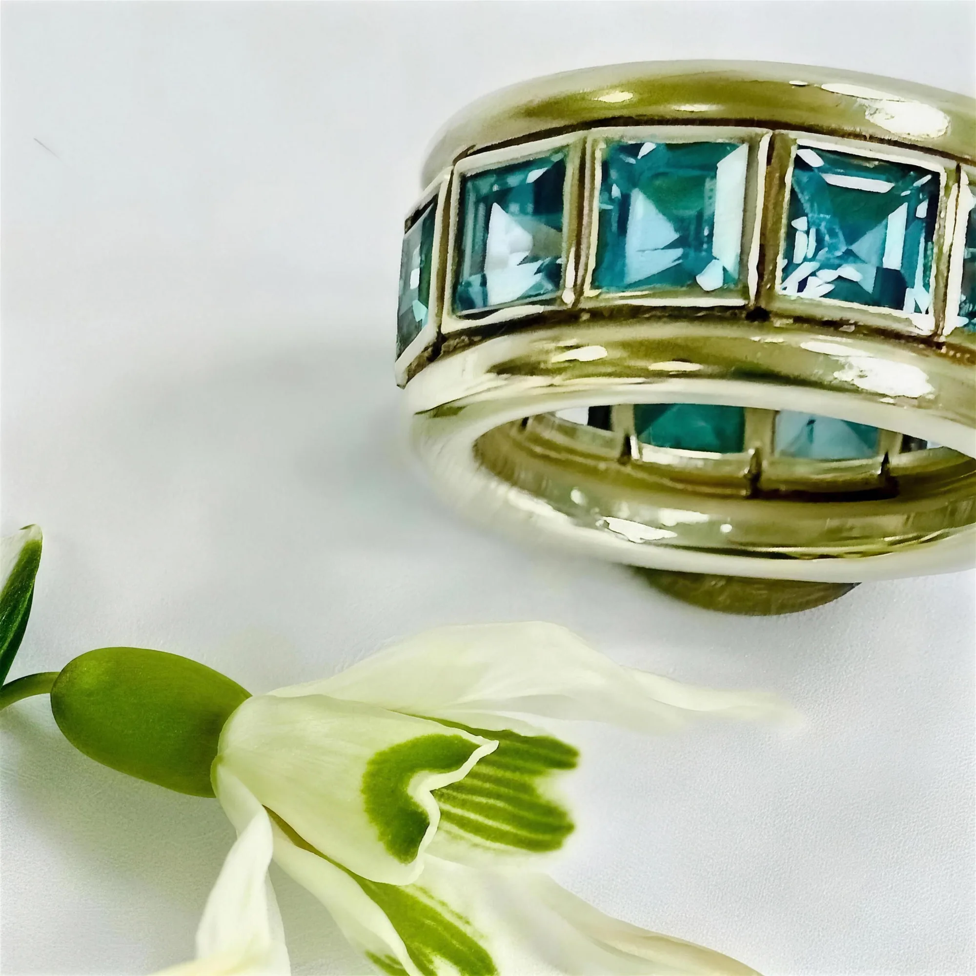 Weißgoldring mit blauen Topasen im Carré-Schliff, rundum gefasst